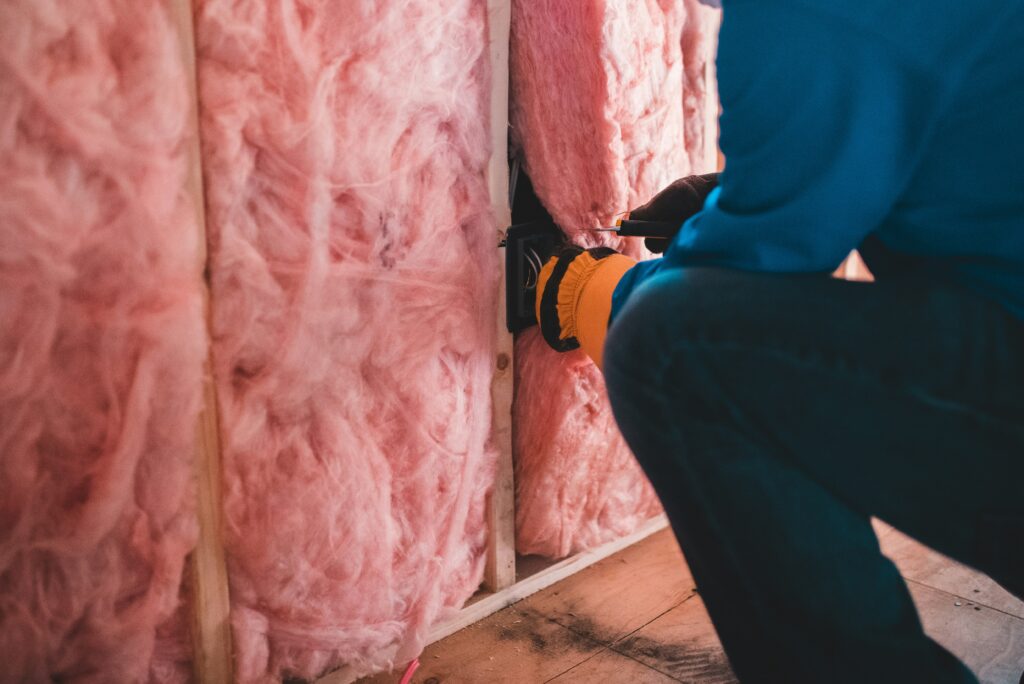 Worker adding insulation to improve energy efficiency during cold weather